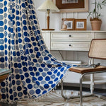 Rideau design avec motifs géométriques bleus, parfait pour ajouter une touche moderne à votre salon. Décoration intérieure élégante avec un mobilier en bois et un éclairage chaleureux. Style tendance et contemporain pour sublimer votre espace de vie.