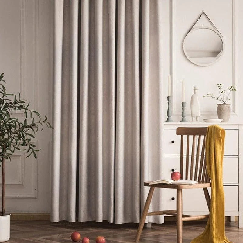 Rideau élégant de couleur neutre dans un intérieur moderne. Ce rideau s'intègre parfaitement dans une décoration épurée grâce à sa teinte douce et apaisante. Idéal pour créer une ambiance chaleureuse et confortable. Parfait pour les salons ou chambres, ce rideau offre une touche de raffinement et d'intimité à votre espace de vie.