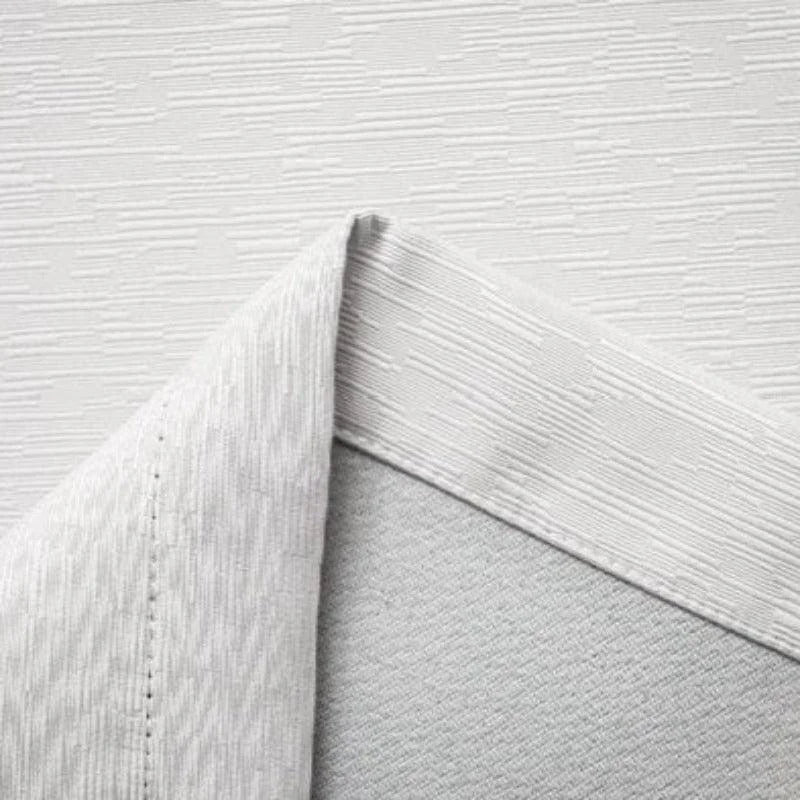 Gros plan sur un revêtement mural blanc aux motifs modernes texturés, idéal pour une décoration intérieure élégante. Parfait pour apporter une touche contemporaine et raffinée à n'importe quelle pièce.