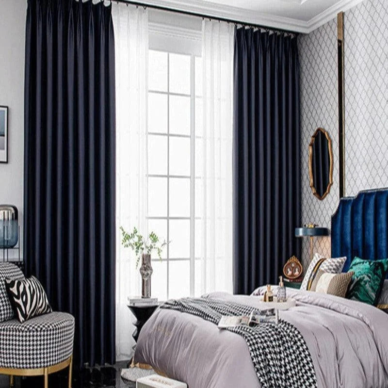Chambre élégante avec rideaux opaques et voilages blancs, idéale pour une décoration moderne. Lit confortable avec couvre-lit dans des tons neutres, offrant une ambiance de détente. Accessoires décoratifs et mobilier chic complètent l'esthétique contemporaine de la pièce. Parfait pour un intérieur raffiné et accueillant.