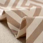 Tissu beige à motifs géométriques de chevrons pour décoration intérieure, idéal pour la confection de rideaux, coussins ou ameublement moderne, ambiance raffinée et chaleureuse.