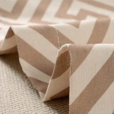 Tissu beige à motifs géométriques de chevrons pour décoration intérieure, idéal pour la confection de rideaux, coussins ou ameublement moderne, ambiance raffinée et chaleureuse.