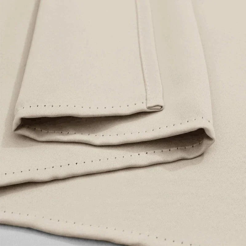 Serviette beige pliée avec coutures décoratives, parfaite pour apporter une touche élégante à votre salle de bain ou cuisine. Accessoire pratique et sophistiqué pour la maison.