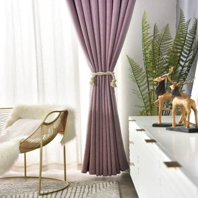 Rideau violet élégant dans un salon moderne, idéal pour apporter une touche de couleur et de sophistication à votre décoration intérieure. Parfait pour filtrer la lumière tout en préservant l'intimité. Ce rideau se marie harmonieusement avec des meubles contemporains et des accents dorés, créant une ambiance chic et chaleureuse. Accessoirisé avec une corde raffinée, il ajoute du caractère à votre espace de vie.