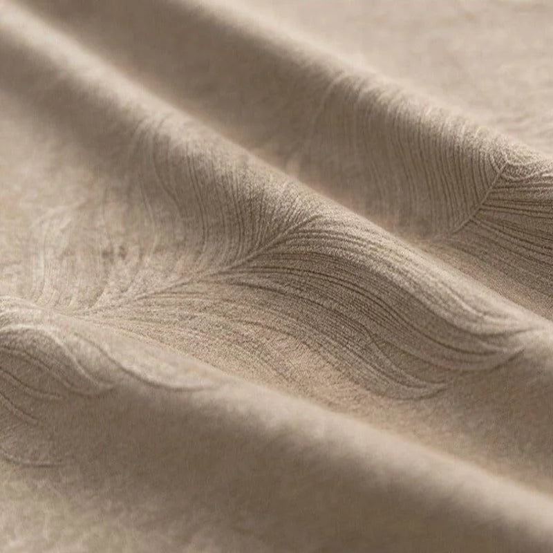 Gros plan sur un tissu beige élégant avec des motifs en relief texturés, idéal pour la décoration intérieure et les projets de couture sophistiqués.