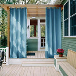 Rideaux d'extérieur bleus suspendus sur une terrasse, offrant intimité et style à l'espace extérieur, parfaits pour embellir jardins et vérandas.