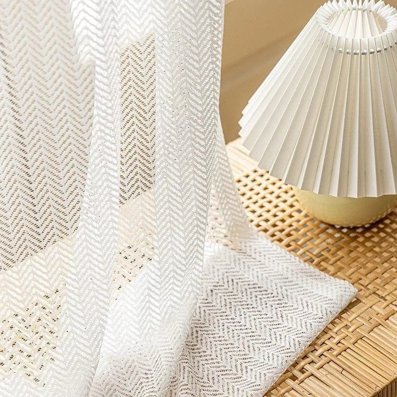 Voilage blanc élégant avec motif à chevrons, idéal pour un salon moderne. Ce rideau lumineux apporte une touche de sophistication et de simplicité, parfait pour filtrer la lumière naturelle. Accessoire de décoration qui complète harmonieusement un espace de vie contemporain.
