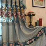 Rideau élégant avec motifs floraux colorés, idéal pour ajouter une touche de charme et de sophistication à votre salon ou chambre. Décoration intérieure classique avec fleurs sur fond bleu et bordures détaillées, parfait pour une ambiance chaleureuse. Accessoire de maison chic et romantique, s'harmonise bien avec différents styles de mobilier.
