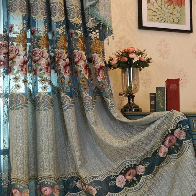 Rideau élégant avec motifs floraux colorés, idéal pour ajouter une touche de charme et de sophistication à votre salon ou chambre. Décoration intérieure classique avec fleurs sur fond bleu et bordures détaillées, parfait pour une ambiance chaleureuse. Accessoire de maison chic et romantique, s'harmonise bien avec différents styles de mobilier.