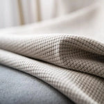 Plaid beige doux et élégant, idéal pour la décoration intérieure, apportant confort et style à votre salon ou chambre à coucher. Parfait pour se réchauffer lors de soirées fraîches ou pour ajouter une touche de sophistication à votre espace de vie.