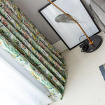Rideau coloré avec motifs tropicaux dans un intérieur moderne, accompagné d'un cadre décoratif et d'une lampe élégante. Accessoire parfait pour ajouter une touche exotique et lumineuse à votre décoration intérieure.
