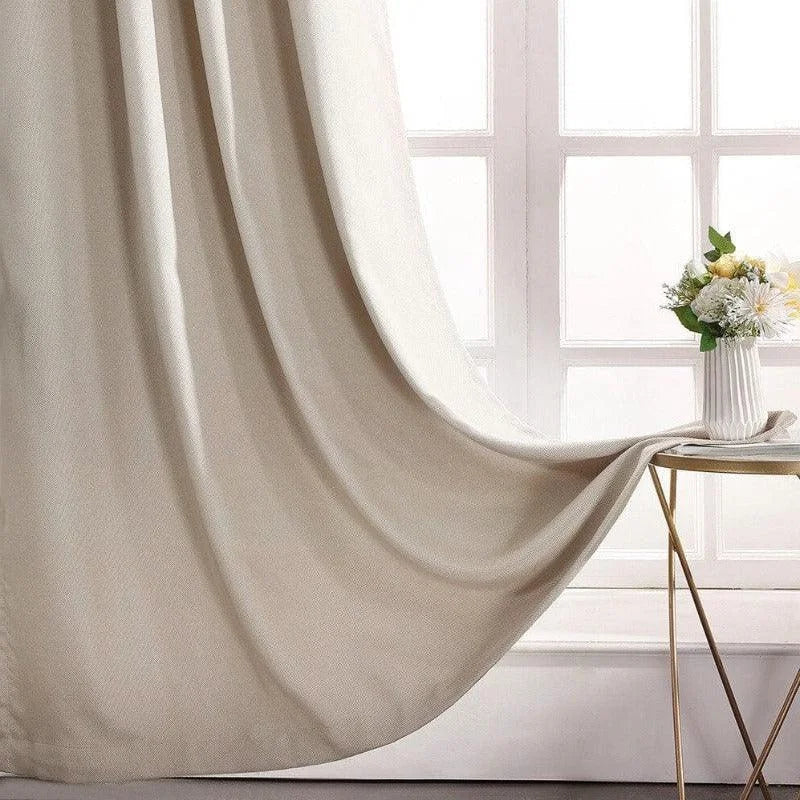 Rideau élégant de couleur beige suspendu près d'une fenêtre lumineuse, idéal pour ajouter une touche sophistiquée à votre salon. Décoration intérieure moderne avec une petite table dorée ornée d'un vase de fleurs blanches et jaunes. Solution parfaite pour créer une ambiance chaleureuse et accueillante dans votre espace de vie.