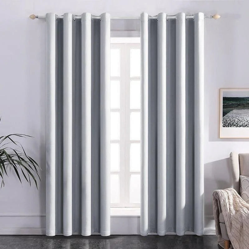 Rideaux opaques gris dans un salon moderne, suspendus à une tringle devant une fenêtre lumineuse. Décoration intérieure élégante avec une plante verte et un tableau encadré. Accessoire idéal pour une ambiance cosy et intimiste.