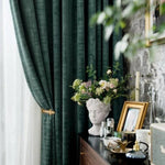 Rideaux élégants de couleur vert foncé ajoutant une touche de sophistication à votre salon. Parfait pour créer une ambiance chaleureuse et accueillante. Décoration intérieure avec vase artistique et cadre photo sur une commode. Améliorez votre espace avec ces éléments de design raffinés.
