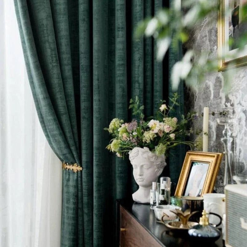 Rideaux élégants de couleur vert foncé ajoutant une touche de sophistication à votre salon. Parfait pour créer une ambiance chaleureuse et accueillante. Décoration intérieure avec vase artistique et cadre photo sur une commode. Améliorez votre espace avec ces éléments de design raffinés.