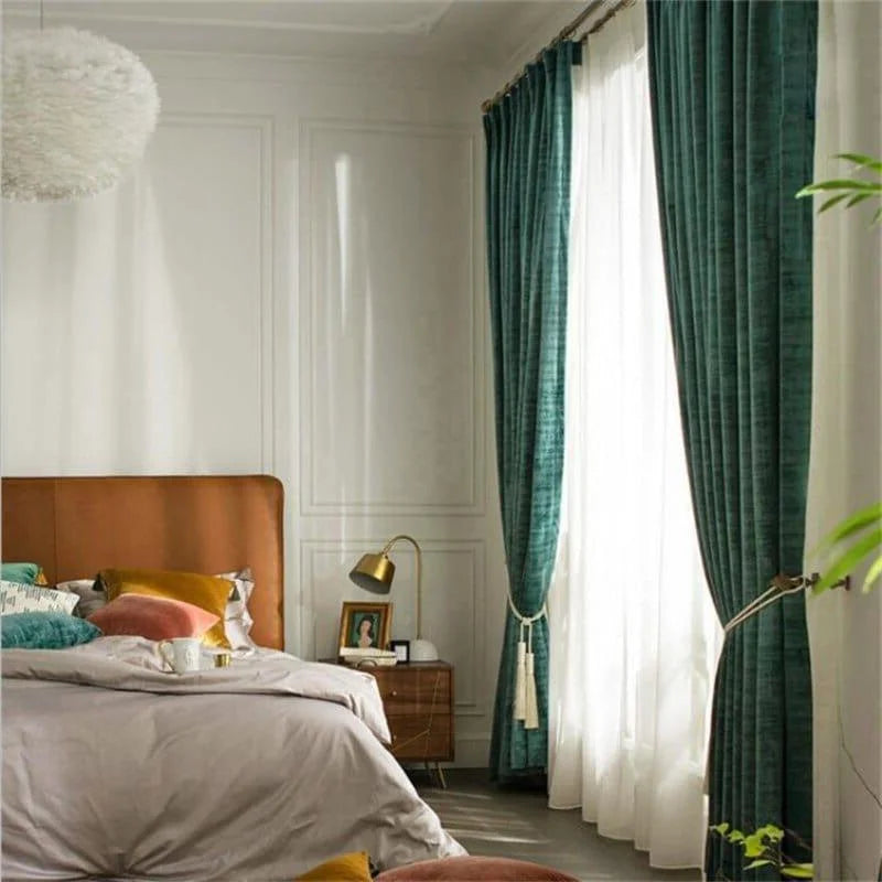 Chambre élégante avec rideaux vert foncé et décoration chaleureuse. Lit double confortable avec coussins colorés, lampe de chevet dorée et table de nuit en bois. Ambiance lumineuse idéale pour un espace accueillant et relaxant. Parfait pour améliorer la décoration intérieure de votre chambre à coucher.