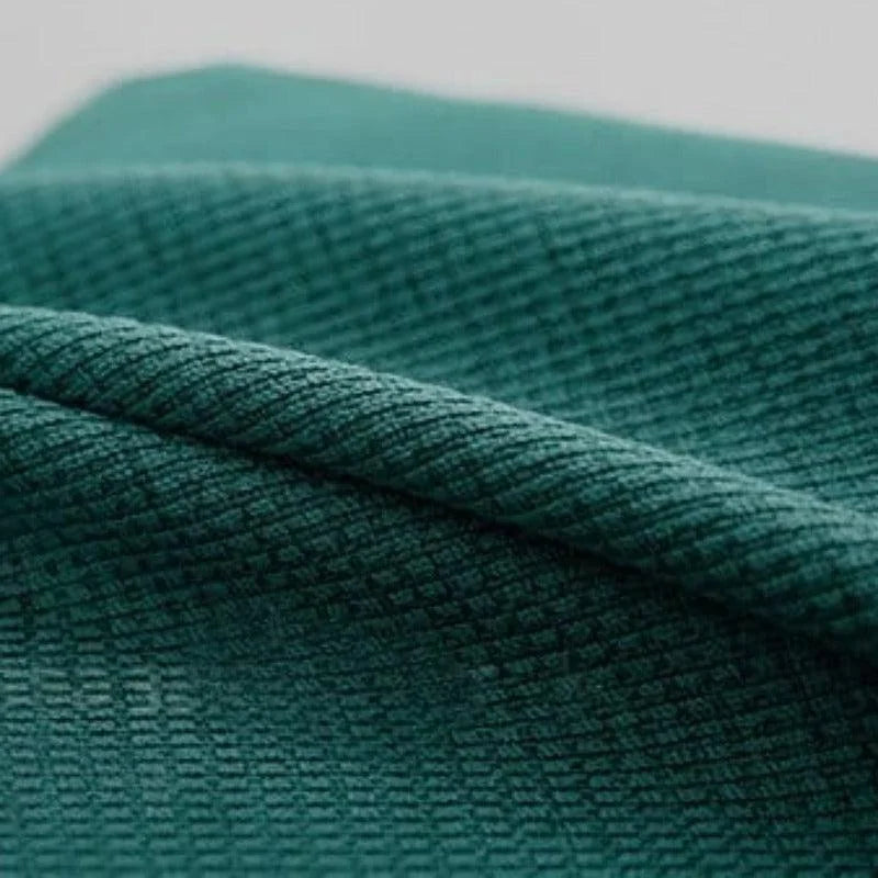 Tissu vert texturé plié, gros plan montrant les détails et le motif du textile. Parfait pour confection textile et projets créatifs, offre un aspect sophistiqué et tendance.