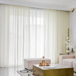 Rideaux élégants pour salon moderne, apportant lumière naturelle et ambiance raffinée. Décoration intérieure minimaliste avec table basse dorée et accessoires contemporains. Idéal pour créer une atmosphère chaleureuse et accueillante dans votre espace de vie.