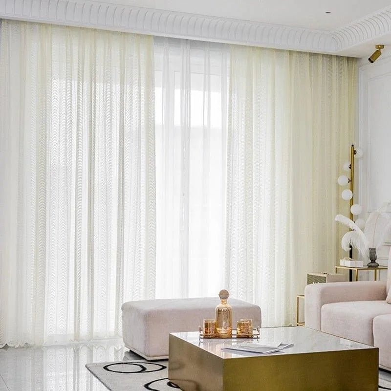 Rideaux élégants pour salon moderne, apportant lumière naturelle et ambiance raffinée. Décoration intérieure minimaliste avec table basse dorée et accessoires contemporains. Idéal pour créer une atmosphère chaleureuse et accueillante dans votre espace de vie.