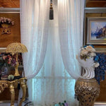 Rideaux élégants avec motifs délicats, ornant une fenêtre avec une décoration luxueuse. Parfait pour ajouter une touche de raffinement à votre intérieur avec un style classique. Présentés dans un cadre richement décoré, ces rideaux apportent un charme intemporel et sophistiqué. Idéal pour un salon ou une chambre à la décoration soignée, créant une ambiance chaleureuse et accueillante.