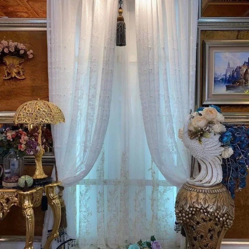 Rideaux élégants avec motifs délicats, ornant une fenêtre avec une décoration luxueuse. Parfait pour ajouter une touche de raffinement à votre intérieur avec un style classique. Présentés dans un cadre richement décoré, ces rideaux apportent un charme intemporel et sophistiqué. Idéal pour un salon ou une chambre à la décoration soignée, créant une ambiance chaleureuse et accueillante.
