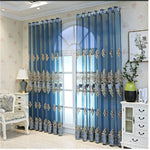 Rideaux élégants de couleur bleue, ornés de motifs décoratifs, suspendus sur une fenêtre avec une vue lumineuse. Idéal pour ajouter du charme à votre salon ou chambre à coucher. Parfait pour une décoration intérieure sophistiquée, ces rideaux apportent une touche de raffinement à votre espace tout en optimisant la lumière naturelle.