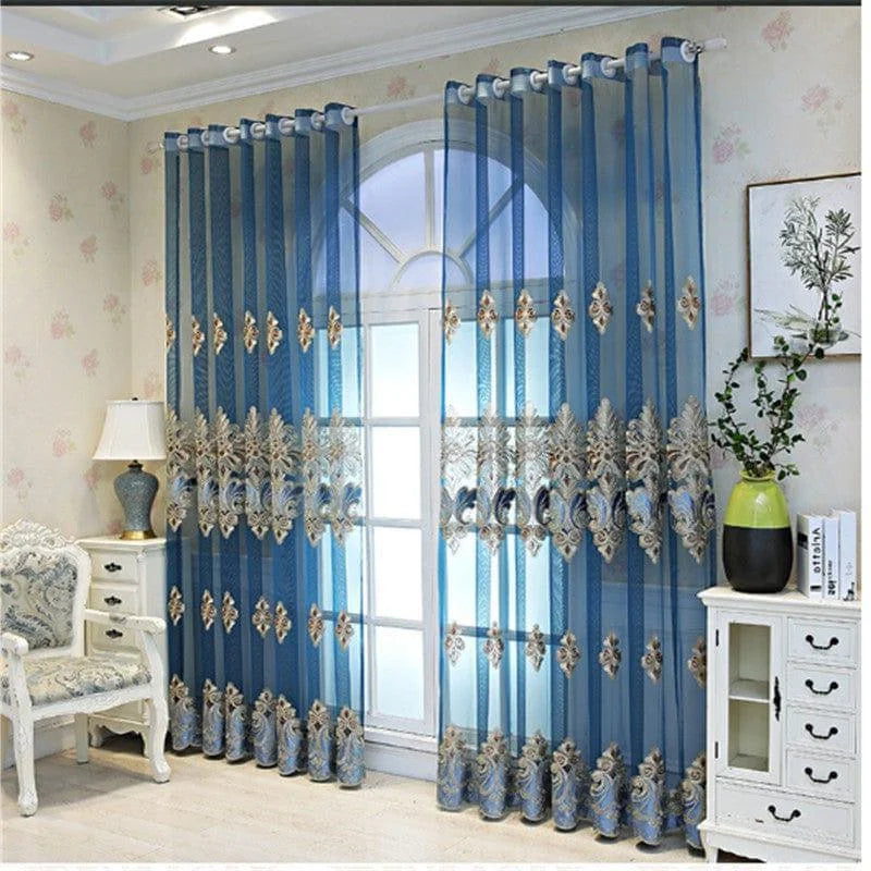 Rideaux élégants de couleur bleue, ornés de motifs décoratifs, suspendus sur une fenêtre avec une vue lumineuse. Idéal pour ajouter du charme à votre salon ou chambre à coucher. Parfait pour une décoration intérieure sophistiquée, ces rideaux apportent une touche de raffinement à votre espace tout en optimisant la lumière naturelle.