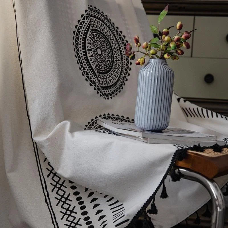 Image d'un élégant vase côtelé bleu clair posé sur un livre, entouré d'un tissu au design mandala noir et blanc, idéal pour rehausser la décoration intérieure avec une touche artistique et moderne. Parfaite harmonie entre éléments décoratifs contemporains et classiques, convie une ambiance apaisante et stylisée à votre espace de vie.