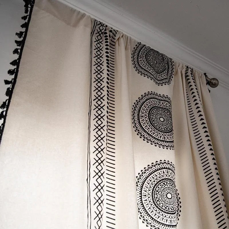 Rideau design avec motifs ethniques noirs et blancs, idéal pour décorer un salon moderne ou une chambre à coucher. Ce modèle original de rideau offre une touche d'élégance et de style, grâce à ses motifs géométriques circulaires et ses bordures détaillées. Parfait pour ajouter une ambiance chaleureuse et contemporaine à votre intérieur.
