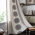 Rideau décoratif blanc avec motifs circulaires noirs, idéal pour ajouter une touche bohème à votre intérieur. Parfait pour filtrer la lumière tout en apportant une ambiance chaleureuse et élégante à votre salon ou chambre. Idéal pour les amateurs de design d'intérieur recherchant un style unique et apaisant.
