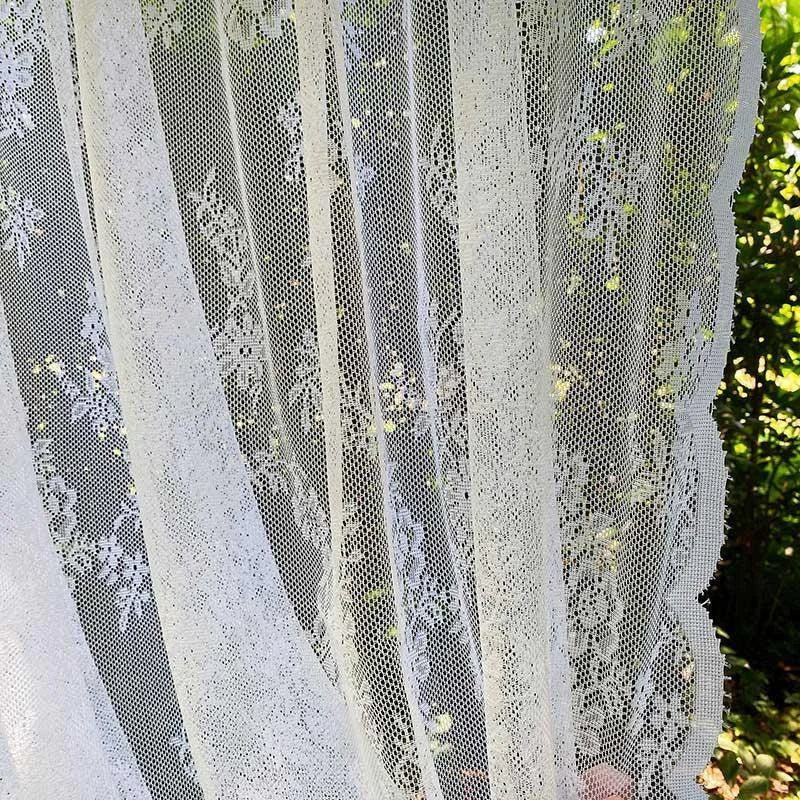 Voilage décoratif blanc avec motifs floraux, idéal pour ajouter une touche élégante et intemporelle à votre intérieur. Parfait pour filtrer subtilement la lumière tout en préservant l'intimité de votre espace de vie. Accessoire de décoration raffiné, s'harmonise avec divers styles d'aménagement intérieur.