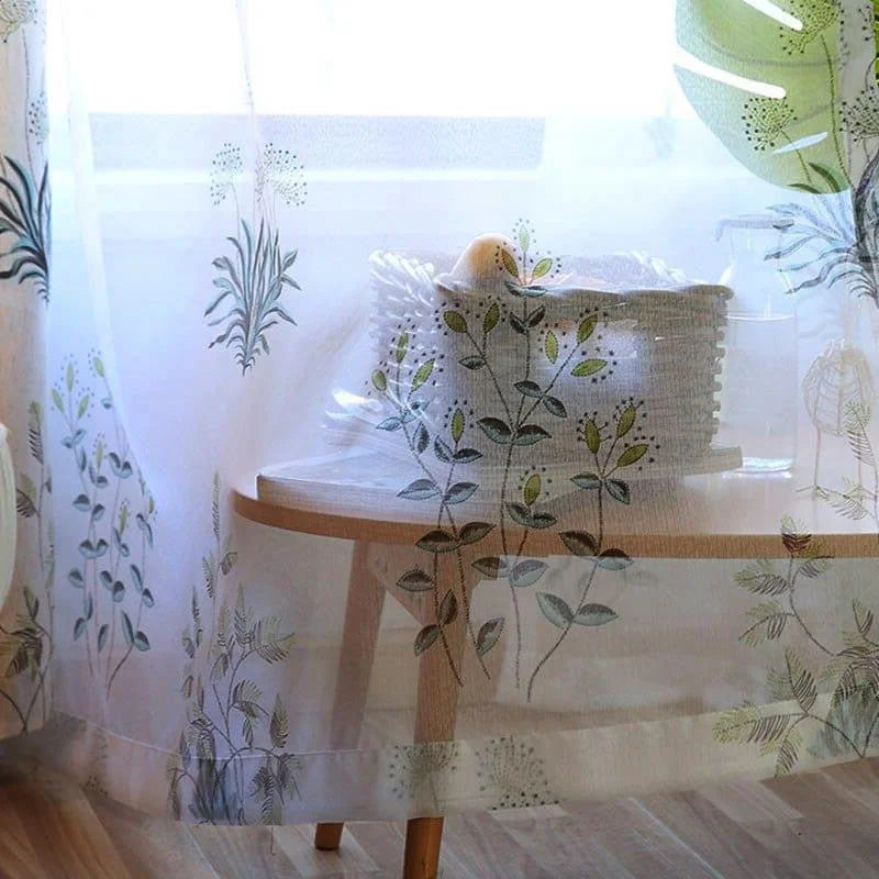 Voilage décoratif floral pour fenêtre, offrant une ambiance naturelle et lumineuse. Parfait pour ajouter une touche de fraîcheur à votre intérieur tout en permettant une belle entrée de lumière. Design élégant avec motifs végétaux.