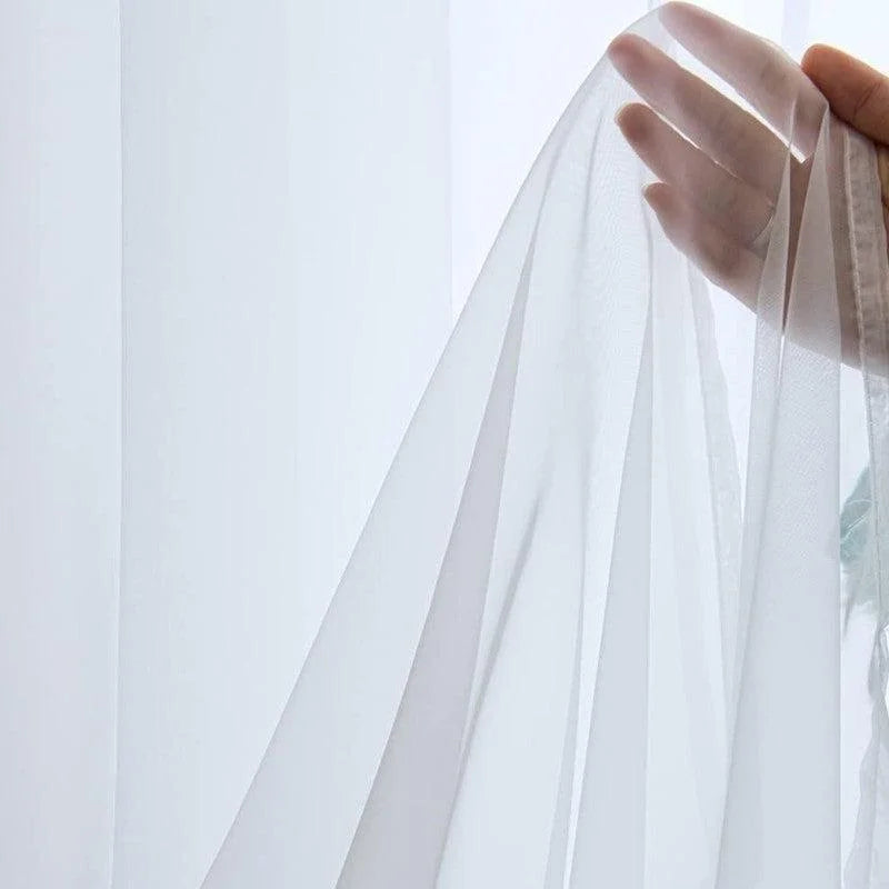 Voilage blanc translucide, idéal pour une ambiance lumineuse et élégante dans votre intérieur. Parfait pour filtrer délicatement la lumière tout en préservant l'intimité. Accessoire décoratif incontournable pour les fenêtres modernes.