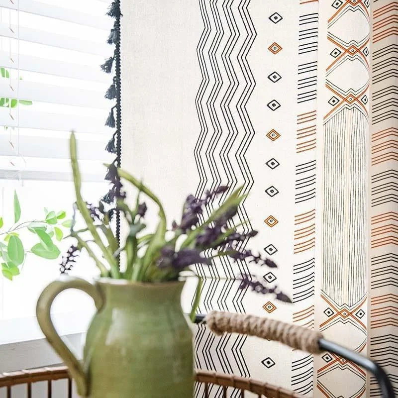 Rideau moderne aux motifs géométriques dans des tons noirs et orangés, apportant une touche élégante à votre intérieur. Associé à un pichet vert contenant un bouquet de fleurs, cet ensemble dégage une atmosphère chaleureuse et accueillante dans la pièce. Idéal pour un salon ou une chambre, ce rideau est un choix parfait pour personnaliser votre décoration intérieure avec style.