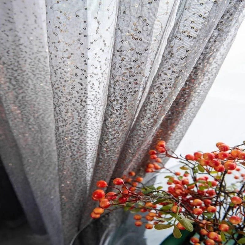 Rideau scintillant avec motifs délicats et détails brillants, accompagné de branches de fruits rouges décoratifs. Élégance et style pour la décoration intérieure.