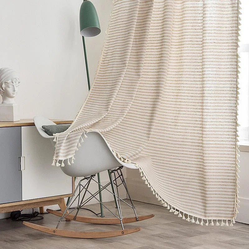 Couverture décorative avec motif rayé beige et blanc, mettant en valeur un salon moderne et épuré. Élégamment drapée sur un fauteuil à bascule, cette couverture est parfaite pour ajouter une touche cosy à votre espace de vie. Idéale pour les amateurs de décoration intérieure à la recherche de confort et de style.