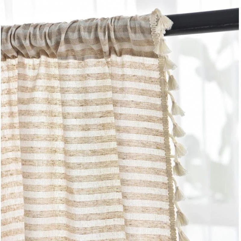 Rideau élégant à rayures beiges et blanches avec franges, idéal pour une décoration intérieure moderne et chaleureuse. Ce rideau apportera une touche de charme à votre salon ou chambre, garantissant une ambiance lumineuse et accueillante. Aperçu d'une installation sur tringle, facile à mettre en place, il s'adapte à tous types d'intérieurs.
