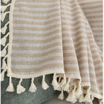 Élégant plaid à rayures beige et blanc avec franges décoratives, idéal pour ajouter une touche de style boho-chic à votre salon ou chambre à coucher. Parfait pour se réchauffer lors des soirées fraîches. Accessoire déco tendance pour toutes saisons.
