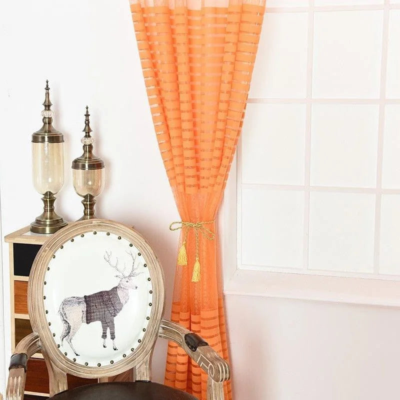 Chaise élégante avec motif de renne placée devant une fenêtre ornée de rideaux orange, accompagnée de deux lampes décoratives. Décoration intérieure moderne et chaleureuse, idéale pour un salon accueillant. Parfait pour apporter une touche originale et stylée à votre espace de vie.