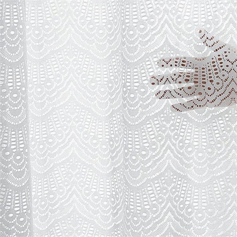 Rideau décoratif blanc avec motifs ajourés élégants. Offre une touche raffinée et délicate à votre intérieur, tout en laissant passer la lumière douce. Idéal pour créer une ambiance chaleureuse dans le salon ou la chambre. Motif en arabesques pour un style classique et chic.