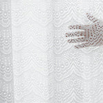 Rideau décoratif blanc avec motifs ajourés élégants. Offre une touche raffinée et délicate à votre intérieur, tout en laissant passer la lumière douce. Idéal pour créer une ambiance chaleureuse dans le salon ou la chambre. Motif en arabesques pour un style classique et chic.