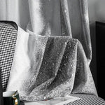 Rideau élégant à motifs argentés, drapé sur une chaise à motifs noirs et blancs. Ce rideau moderne ajoute une touche sophistiquée à tout intérieur, parfait pour créer une ambiance rafraîchissante et chic dans votre salon ou chambre à coucher. Idéal pour ceux qui cherchent à allier style et fonctionnalité dans leur décoration.