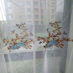 Rideau brodé floral transparent, idéal pour ajouter une touche élégante et décorative à votre intérieur. Le design subtil avec des motifs floraux en bleu et marron rehausse n'importe quelle pièce, offrant une ambiance lumineuse et apaisante. Solution parfaite pour ceux qui souhaitent combiner esthétique et fonctionnalité dans leur décoration de fenêtres.