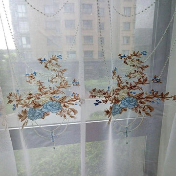 Rideau brodé floral transparent, idéal pour ajouter une touche élégante et décorative à votre intérieur. Le design subtil avec des motifs floraux en bleu et marron rehausse n'importe quelle pièce, offrant une ambiance lumineuse et apaisante. Solution parfaite pour ceux qui souhaitent combiner esthétique et fonctionnalité dans leur décoration de fenêtres.