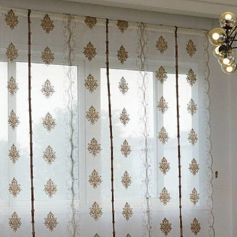 Voilage élégant à motifs dorés, idéal pour décorer les fenêtres de votre salon ou chambre avec style. Ce rideau transparent permet de filtrer délicatement la lumière tout en ajoutant une touche sophistiquée à votre intérieur. Design moderne et chic, parfait pour créer une ambiance chaleureuse et accueillante. Convient à tous types de décoration d'intérieur.