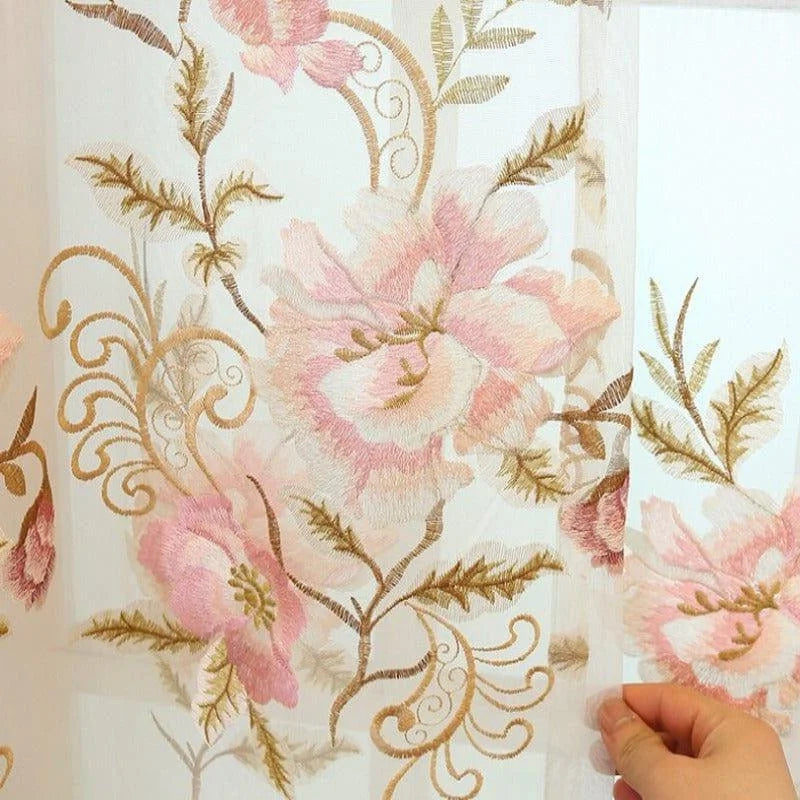 Rideau transparent avec broderie florale rose et beige, idéal pour ajouter une touche élégante et romantique à votre intérieur. Ce voilage raffiné convient parfaitement pour décorer un salon ou une chambre, créant une ambiance douce et chaleureuse. Les motifs floraux délicats ajoutent une dimension artistique à votre décoration intérieure.