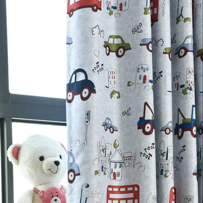 Rideau pour chambre d'enfant avec motifs colorés de voitures et de bâtiments, idéal pour une décoration ludique et joyeuse. Ce rideau ajoute une touche amusante à toute chambre d'enfant, accompagnant joliment un nounours moelleux. Parfait pour stimuler l'imaginaire des petits tout en embellissant leur espace de jeu ou de sommeil.