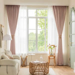 Salon moderne avec rideaux élégants roses encadrant une grande fenêtre laissant entrer la lumière naturelle. Décoration intérieure épurée avec table basse en rotin, canapé confortable et chaises design. Idéal pour aménager un espace convivial et lumineux dans votre maison.