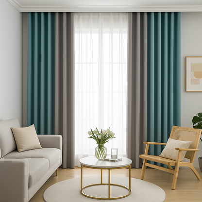 Rideaux occultants bleu vert et gris installés sur rail dans un salon moderne avec canapé beige, fauteuil en bois et table basse ronde dorée.