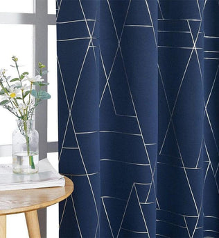 Rideau bleu foncé avec motifs géométriques blancs, idéal pour une décoration moderne. Le vase transparent avec des fleurs blanches sur une table en bois ajoute une touche de naturel et d'élégance à l'ensemble.